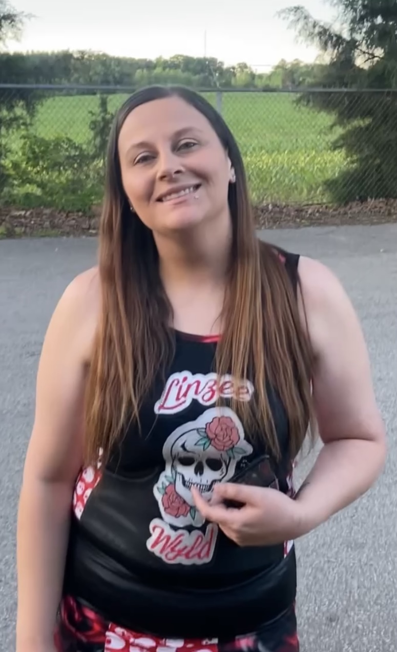 Linzee Wyld smiling outdoors in her wrestling gear